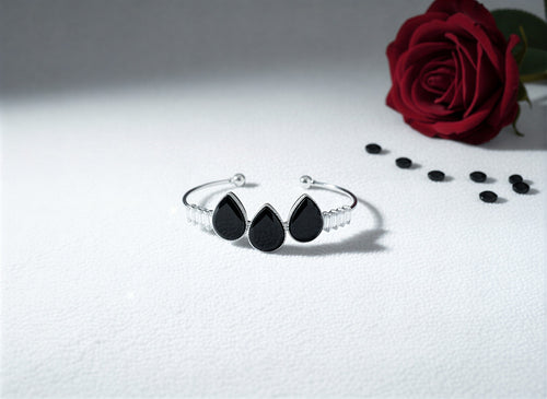 Flexible open-cuff bangle with a pavé crystal heart and dangling pearl.