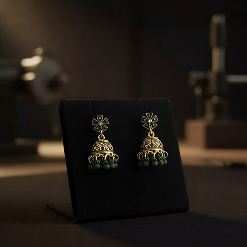 Oxidized silver-toned jhumkas with emerald green detailing.
