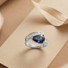 An Avant-Garde Pear-Shaped Deep Blue Solitaire Enveloped in Radiant Crystal Architecture with Dual-Tone Metallic Versatility
