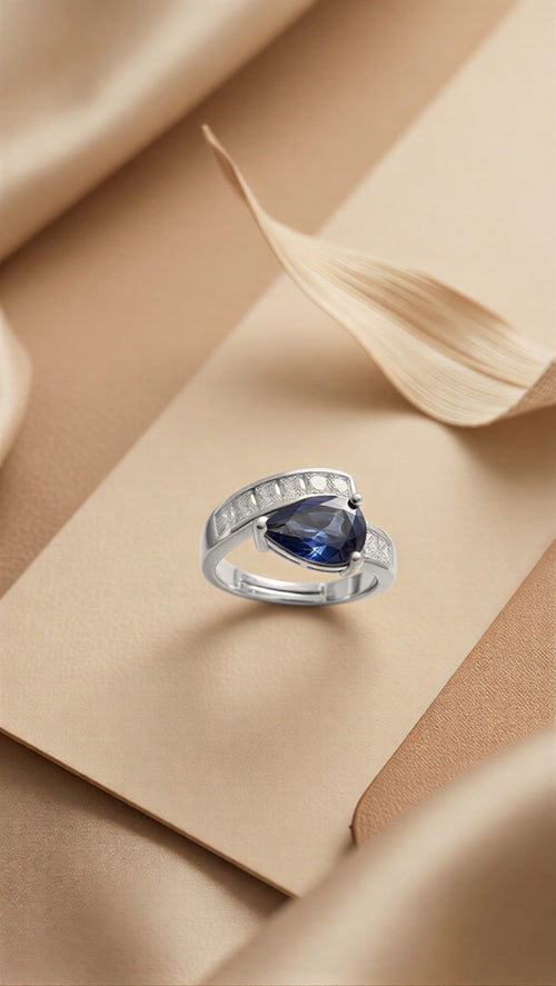 An Avant-Garde Pear-Shaped Deep Blue Solitaire Enveloped in Radiant Crystal Architecture with Dual-Tone Metallic Versatility