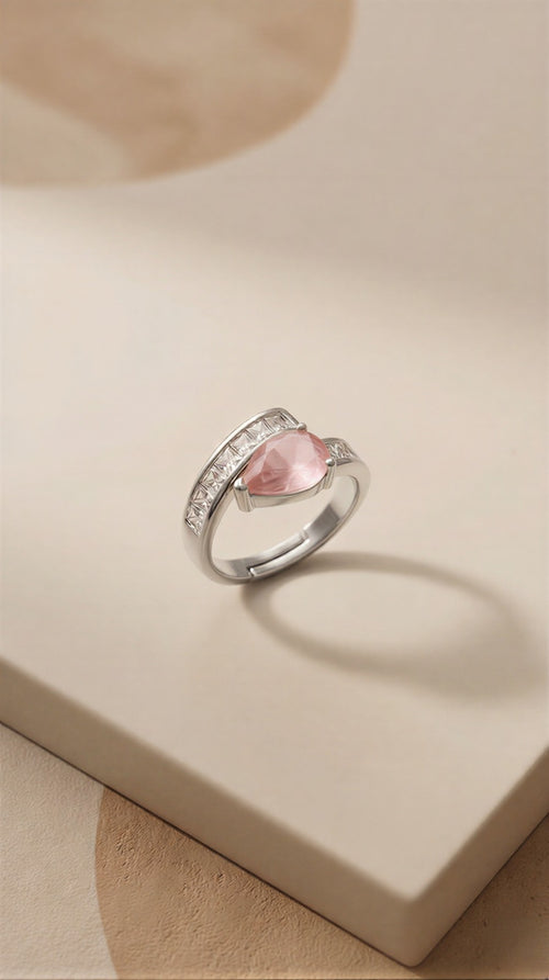 A Sophisticated Adjustable Ring with a Soft Pink Teardrop Stone and Precision-Set Crystals in Dual Metallic Finishes