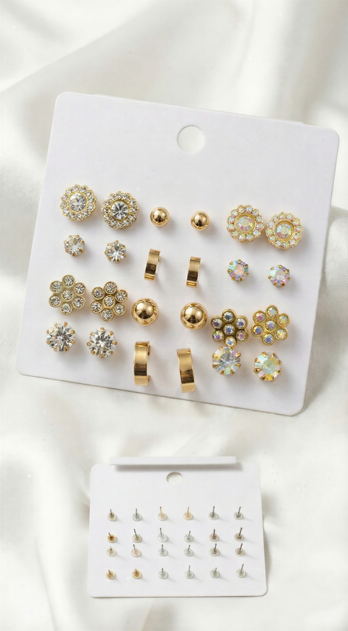 A 12-pair gold-tone earring set on a white card featuring iridescent crystal flowers, gold hoops, metallic spheres, and sparkling multifaceted studs.